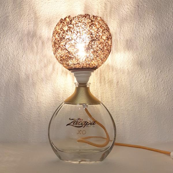 Bouteille d'alcool surmontée d'une boule en dentelle de carton